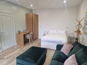 a bedroom with a bed and a couch and a desk at Sea View Studio in Buncrana