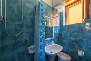 a blue bathroom with a sink and a toilet at La casa di Gio in Isola Rossa