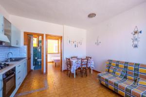 a kitchen and living room with a table and a couch at La casa di Gio in Isola Rossa