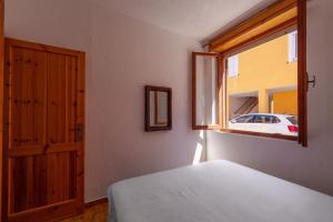 a bedroom with a bed and a window at La casa di Gio in Isola Rossa