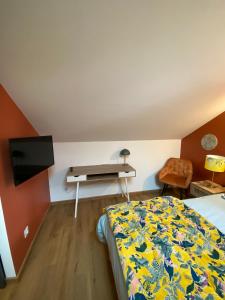 a bedroom with a bed with a desk and a bed sidx sidx sidx at Le Lys Écossais in Aubigny-sur-Nère