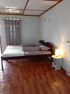 um quarto com uma cama e uma mesa com um candeeiro em Friendly losmen em Lagudri