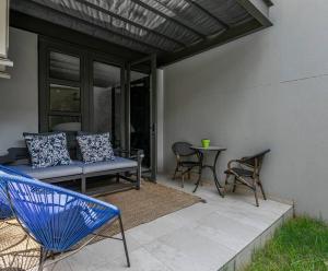 a patio with a bench and a table and chairs at Stylish Apartment w/ inverter 1km 2Hyde Park in Johannesburg