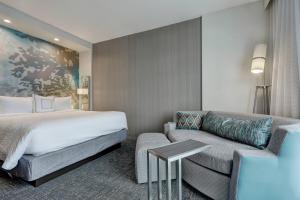 Habitación de hotel con cama y sofá en Courtyard by Marriott Deptford, en Almonesson