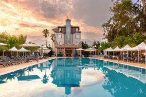 a pool at a resort with chairs and a building at Hotel Chateau Kvirike in K'obulet'i