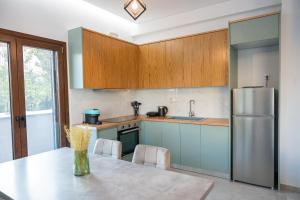 a kitchen with a table and a refrigerator at Orion Residence Ι in Volos