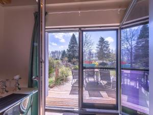 a room with a sliding glass door looking out at a deck at Ferienhaus Kleine Sommerliebe in Warenshof