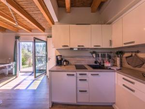 Warenshof的住宿－Ferienhaus Kleine Sommerliebe，厨房铺有木地板,配有白色橱柜。