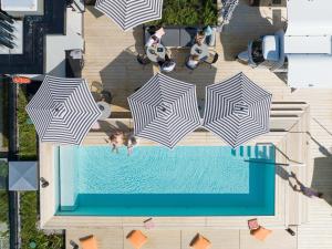 una vista sul tetto di una piscina con ombrelloni di GREFIS Hotel a Monaco