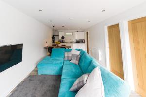 un divano blu in soggiorno con cucina di 2 bedroom luxury beach apartment Millendreath a Saint Martin