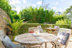 drewniany stół i krzesła na patio w obiekcie Sérénité - 2 chambres - Calme et Verdure w mieście Nantes