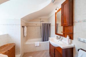 Tremezzina Charming Apartment by Wonderful Italy في تريميزو: حمام مع حوض وحوض استحمام
