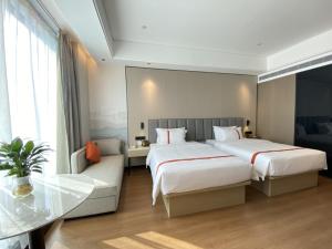 um quarto de hotel com duas camas e uma mesa em GreenTree Eastern Hotel Fuzhou South Railway Station em Fucheu