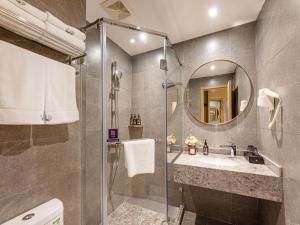 bagno con doccia, lavandino e specchio di Gya Hotel Suzhou Hanshan Temple Binhe Road a Suzhou