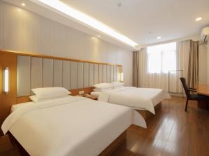 a hotel room with two beds and a desk at GreenTree Alliance Jiangsu Huai'an Suning Plaza in Huai'an
