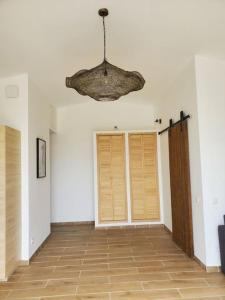 Habitación vacía con lámpara de araña y puertas de madera. en Rêve en Lubéron en Lauris