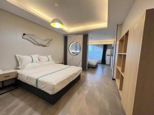 VX Hotel Anhui Suzhou Dangshan Zhongyuan Road في Dangshan: غرفة نوم مع سرير مع فيش على الحائط