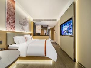 JiangningにあるGreenTree Eastern Hotel Nanjing Jiangning Universityの大型ベッド1台、薄型テレビが備わるホテルルームです。