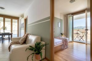 een woonkamer met een bank en een slaapkamer met een balkon bij Penthouse Midori in Florence