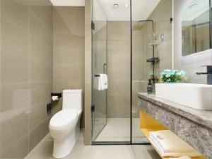 een badkamer met een toilet, een wastafel en een douche bij VX Hotel Dalian Zhoushuizi Airport in Dalian