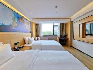 VX Hotel Fuyang Railway Station East Beijing Road في فويانغ: غرفة فندقية بسريرين وتلفزيون