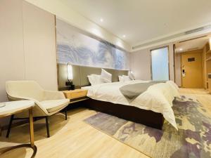 - une chambre avec un grand lit, un bureau et une chaise dans l'établissement GreenTree Eastern Guangxi Baise Wuzhong Sports Center High-Speed Railway Station, à Qitang
