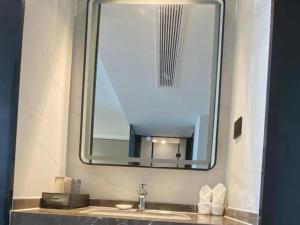 a bathroom sink with a large mirror above it at GreenTree Eastern Hotel Fuyang Jieshou Railway Station East Xinyang Road in Xiaosongzhuang