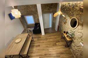 een woonkamer met een houten tafel en een stenen muur bij Casa Rural Depende in Vilagarcia de Arousa