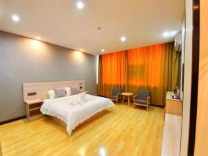 1 dormitorio con 1 cama, mesa y sillas en Geli Hotel Xuzhou Government Olympic Sports Center, en Xuzhou