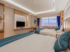 Cette chambre comprend deux lits et une télévision. dans l'établissement GreenTree Eastern Hotel Duyun Wen'an Jinmei Times Bus Station, à Yinzhan