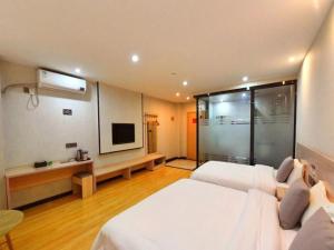 a large room with two beds and a television at Geli Hotel Xuzhou Government Olympic Sports Center in Xuzhou