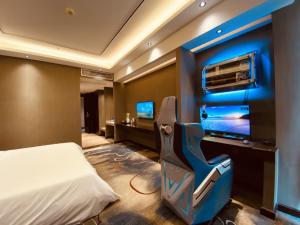 Geli Hotel Bengbu Wanda Plaza Nanxiang City في Bengbu: غرفة نوم فيها سرير وتلفزيون