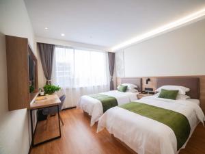 a hotel room with two beds and a desk at GreenTree Inn Express Hotel Fuyang Development Zone Oriental Pearl in Fuyang