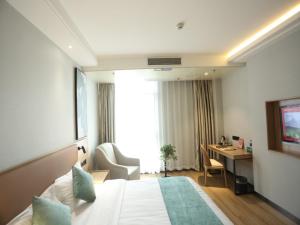Pokój hotelowy z łóżkiem i biurkiem w obiekcie GreenTree Inn Anqing East Yingbin Road High-Speed Railway Station w Anqing