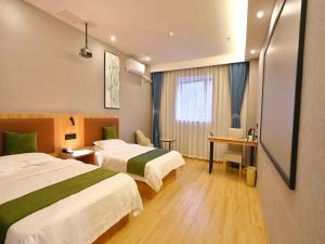 a hotel room with two beds and a desk at GreenTree Inn Express Hotel North Huaihai Road in Huai'an