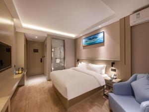una camera con un letto bianco e un divano blu di Gya Hotel Suzhou Hanshan Temple Binhe Road a Suzhou