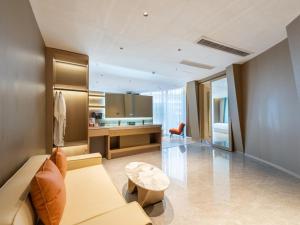 a living room with a couch and a table at VX Hotel Xuzhou Suining Remin Road in Suining
