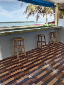 a bar with stools and a view of the ocean at Friendly losmen in Lagudri
