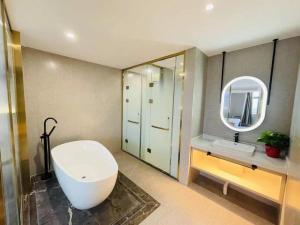 een badkamer met een bad, een wastafel en een spiegel bij VX Hotel Xiao County Railway Station Century Avenue zheshang Market in Mengzhuang