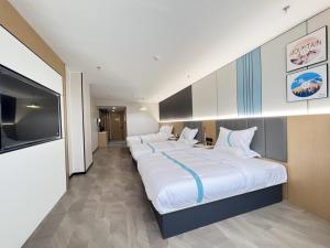 VX Hotel Anhui Suzhou Dangshan Zhongyuan Road في Dangshan: غرفة نوم كبيرة فيها سريرين كبار
