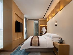 Un pat sau paturi într-o cameră la GreenTree Eastern Hotel Tianjin Wuqing Wanda Plaza