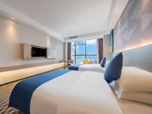 een hotelkamer met 2 bedden en een televisie bij GreenTree Inn Yulin Hongjin Markey Yide in Yulin