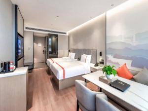um quarto de hotel com uma cama e uma secretária em GreenTree Eastern Hotel Chongqing High-Speed North Railway Station North Square em Chongqing
