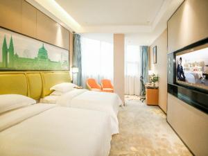 Habitación de hotel con 4 camas y TV de pantalla plana. en GreenTree Eastern Hotel Chongqing Jiefangbei Children's Hospital en Chongqing
