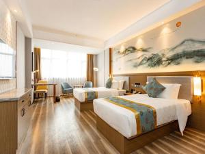 Una habitación de hotel con dos camas y un escritorio. en GreenTree Eastern Hotel Bengbu Huaishang Guogou Plaza Lijing Tiancheng, en Bengbu 50 fotos más