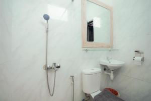 ein Bad mit einer Dusche, einem WC und einem Waschbecken in der Unterkunft El Ora Hotel & Eatery Labuan Bajo in Labuan Bajo