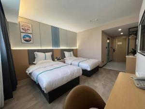 um quarto de hotel com duas camas e uma secretária em VX Hotel Anhui Suzhou Dangshan Zhongyuan Road em Dangshan