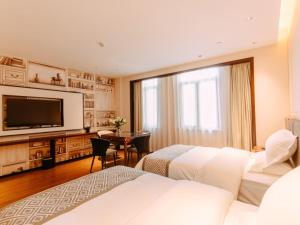 GEM Hotel Bozhou College في Bozhou: غرفة فندقية بسريرين وتلفزيون بشاشة مسطحة