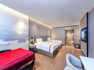 GreenTree Eastern Hotel Chongqing High-Speed North Railway Station North Square في تشونغتشينغ: غرفة فندقية بسرير وتلفزيون بشاشة مسطحة