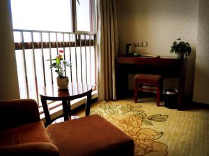 a living room with a couch and a table and a desk at GreenTree Inn Anqing East Yingbin Road High-Speed Railway Station in Anqing